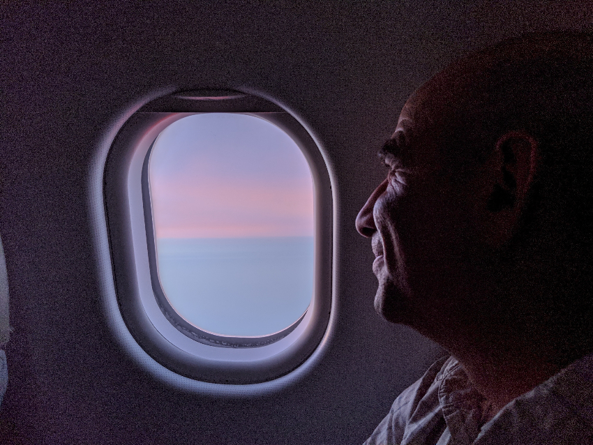 Tom looking out the window of an airplane in flight