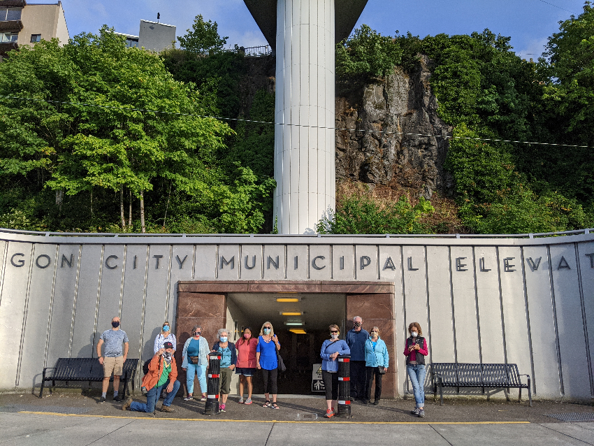 Group posing in front of base of Oregon city elevator