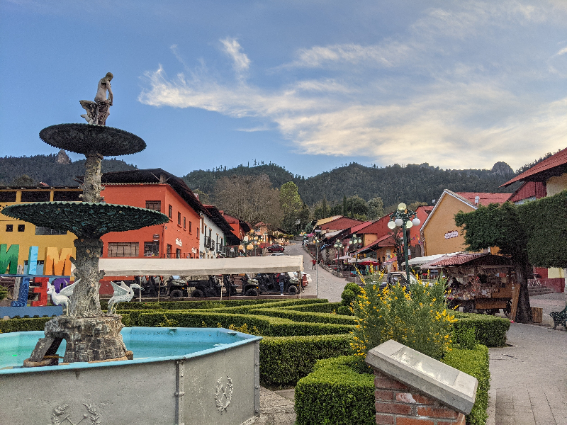 Main square with fountain and mountains in the background at Mineral del Chico