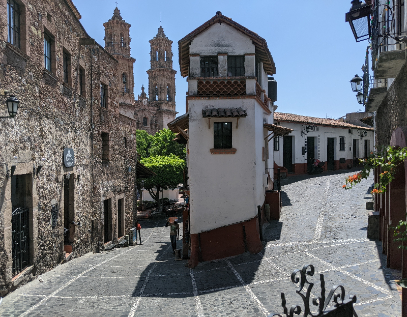 Stone street in Taxco with narrow building and famous tight turn