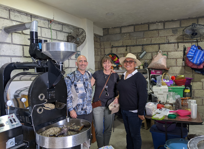 Photo of Tom, Joan, and Ernestina with the coffee bean roaster at Taxkafe