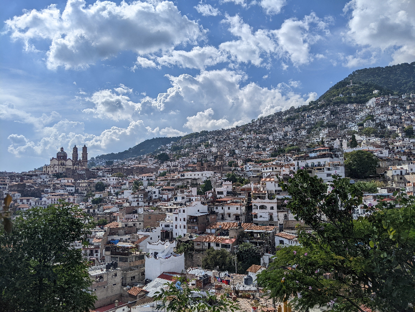 A view of the hilltown of Taxco Mexico with the steeples of Santa Prisca jutting above the skyline